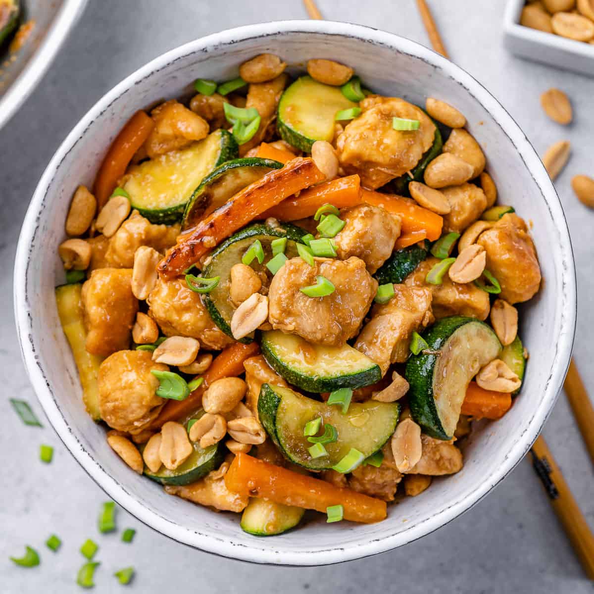 top view sauteed chicken with zucchini and carrots in a white bowl