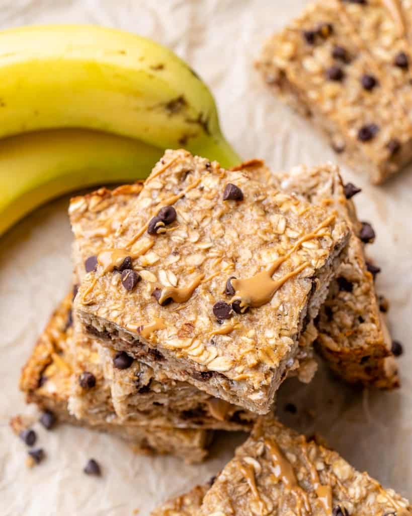 tope view of stacks of oatmeal bars with a side of fresh bananas