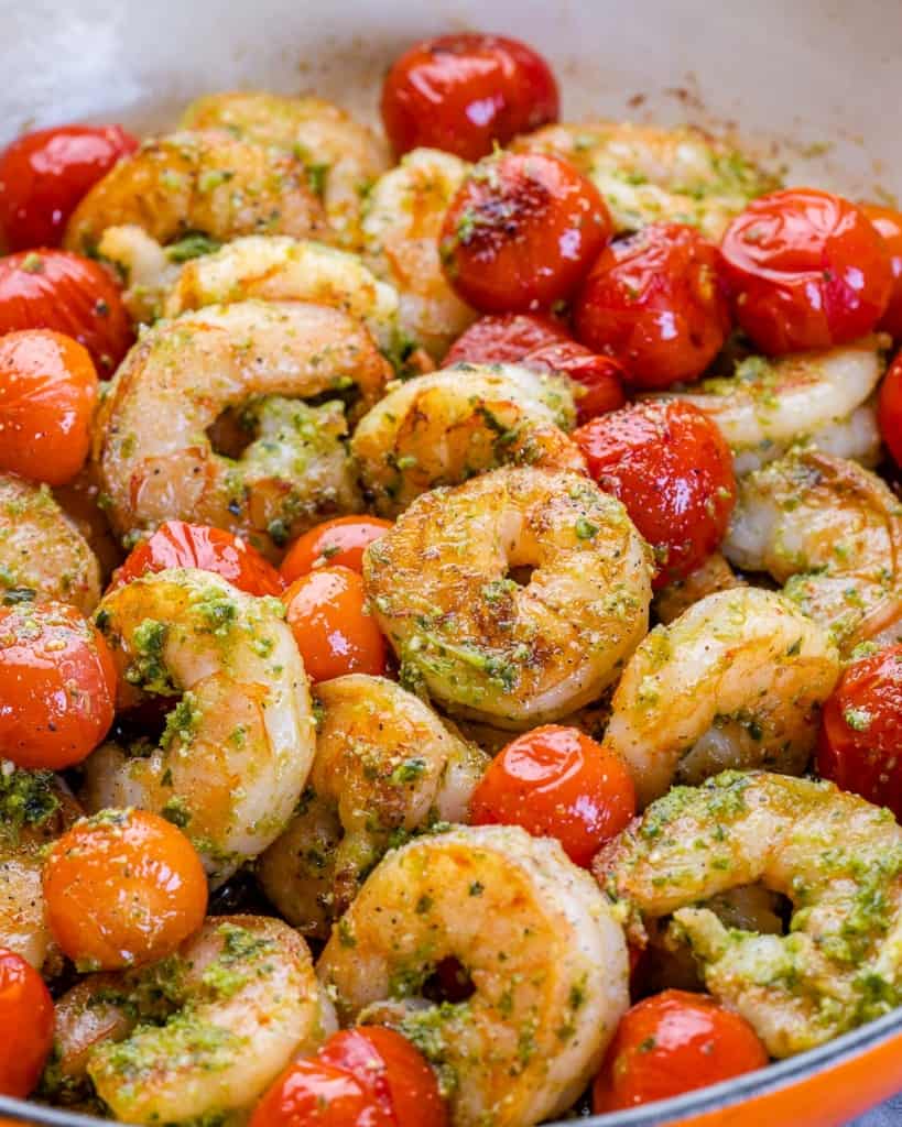 close up view of sauteed shrimp with tomatoes in a pan