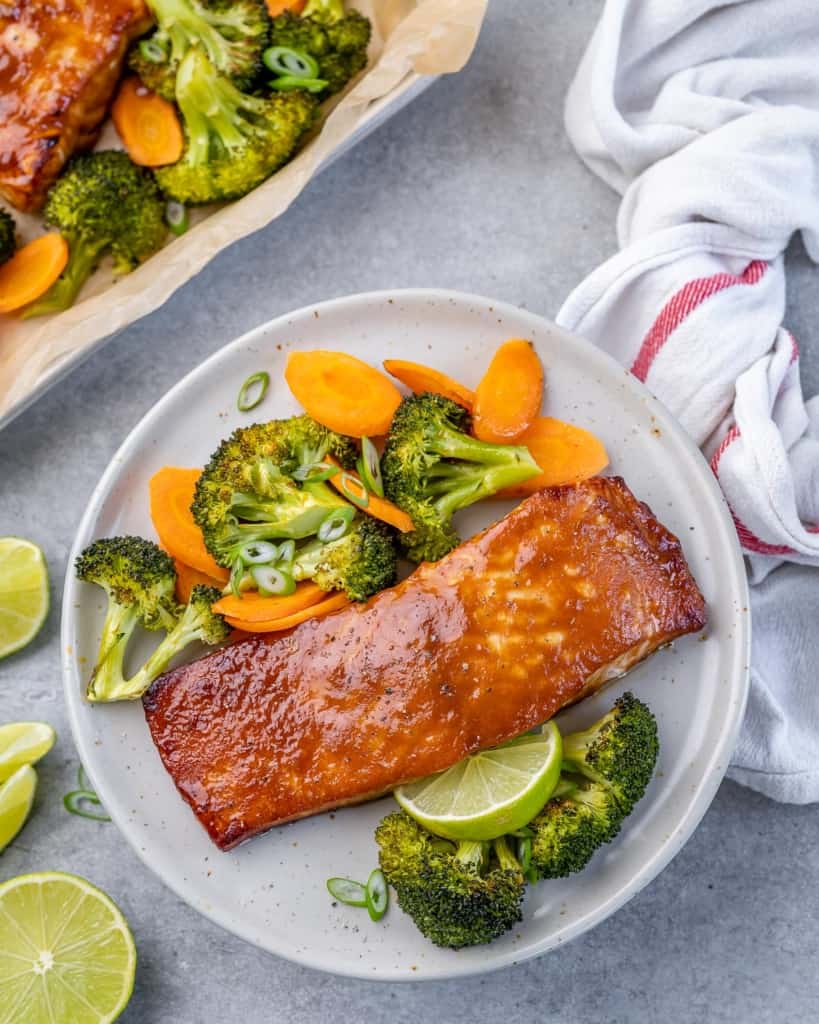 top view salmon filets on a plate with veggies 