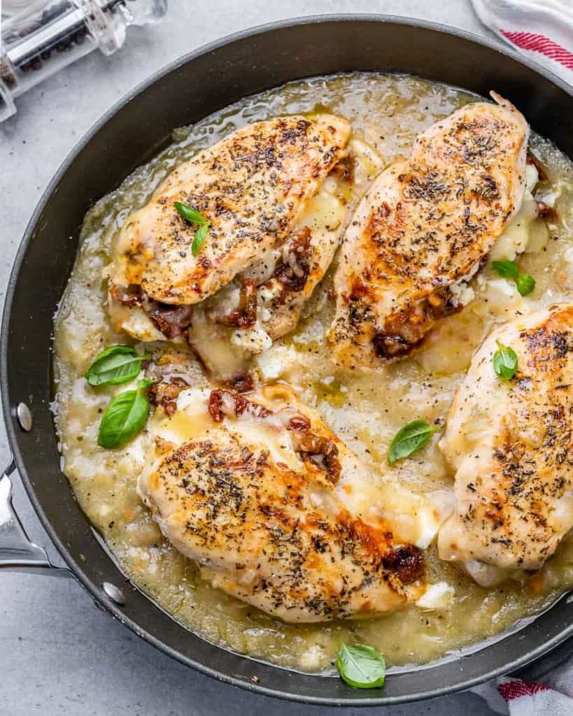 top view of stuffed chicken breast on a skillet in a sauce 