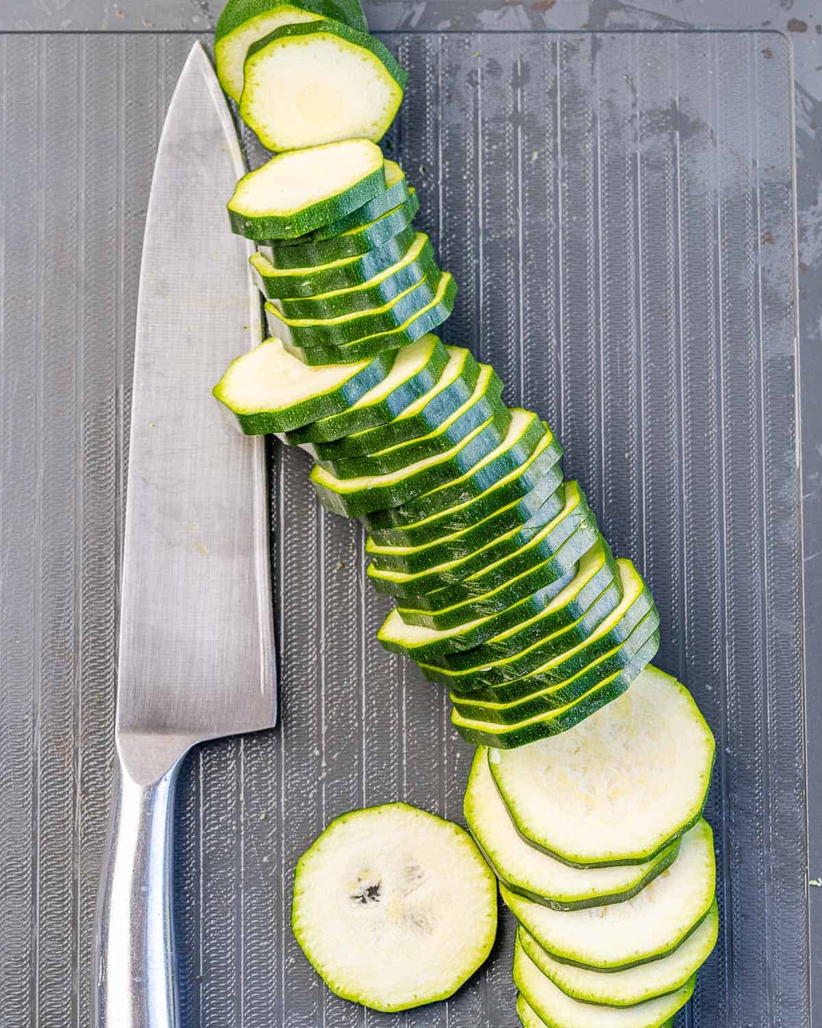 sliced zucchini with knife and cutting board