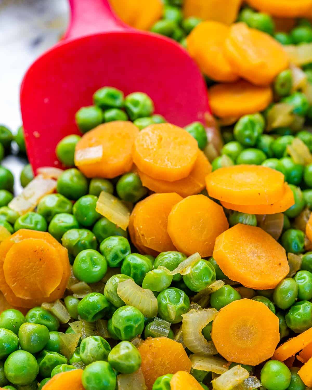 sliced carrots and peas in skillet