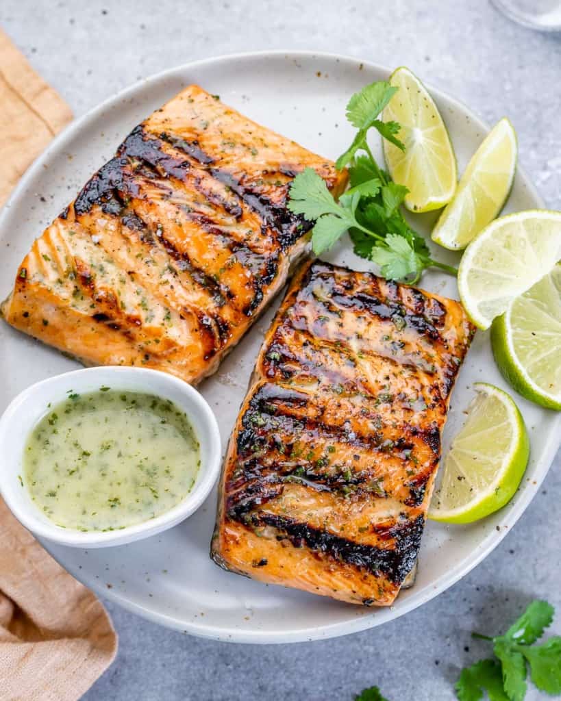 tope view of 2 grilled salmon filets on a white plate 
