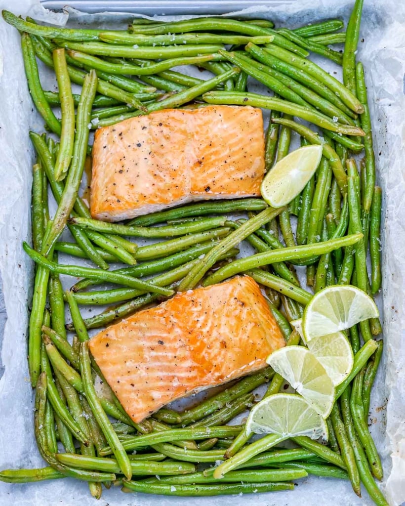 2 baked salmon filets on a pan surrounded with green beans