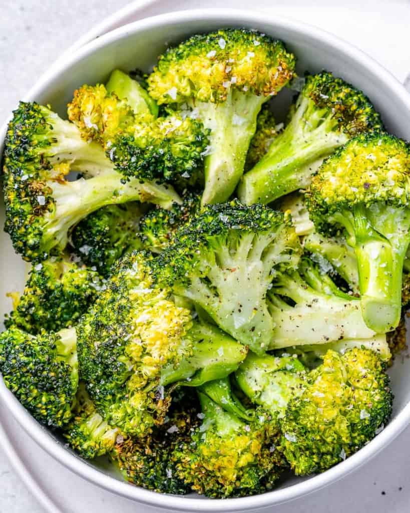 tope view of air fried broccoli in a white bowl