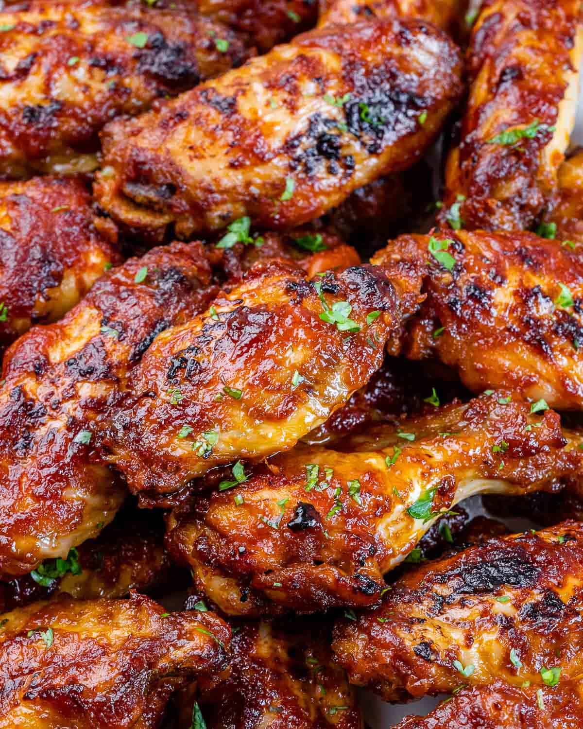 close view of honey baked chicken wings with parsley 