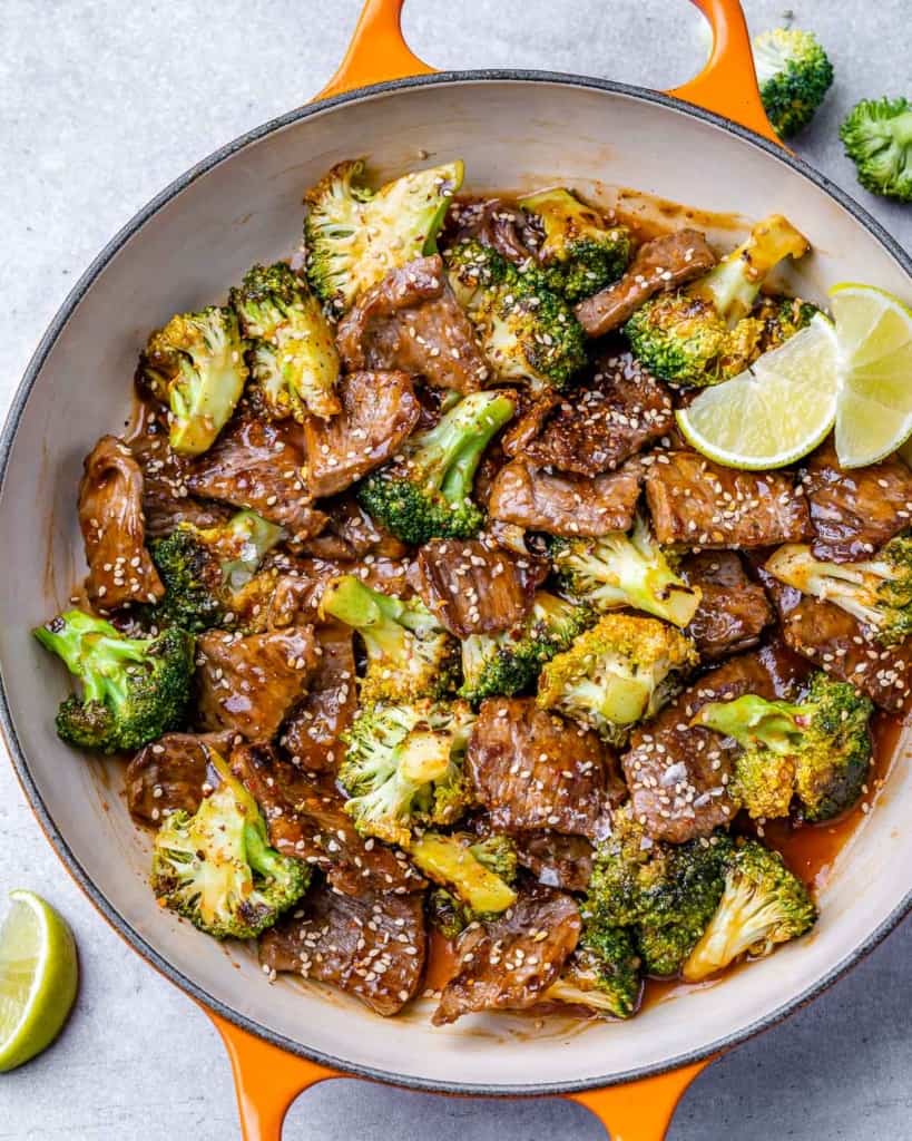 top view beef and broccoli stir fry in an orange skillet