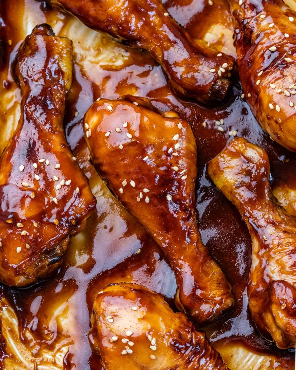 over head shot of baked honey drumsticks topped with a sesame seeds.