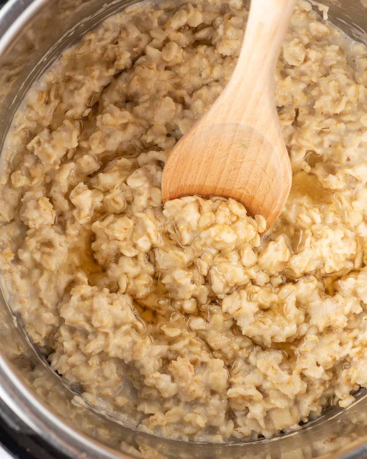 wooden spoon mixing cooked oatmeal in the instant pot