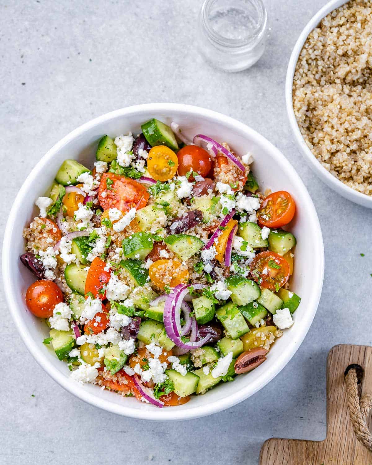 Tossed quinoa salad in circular white bowl. 