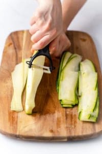 peeler peeling thin layer of zucchini