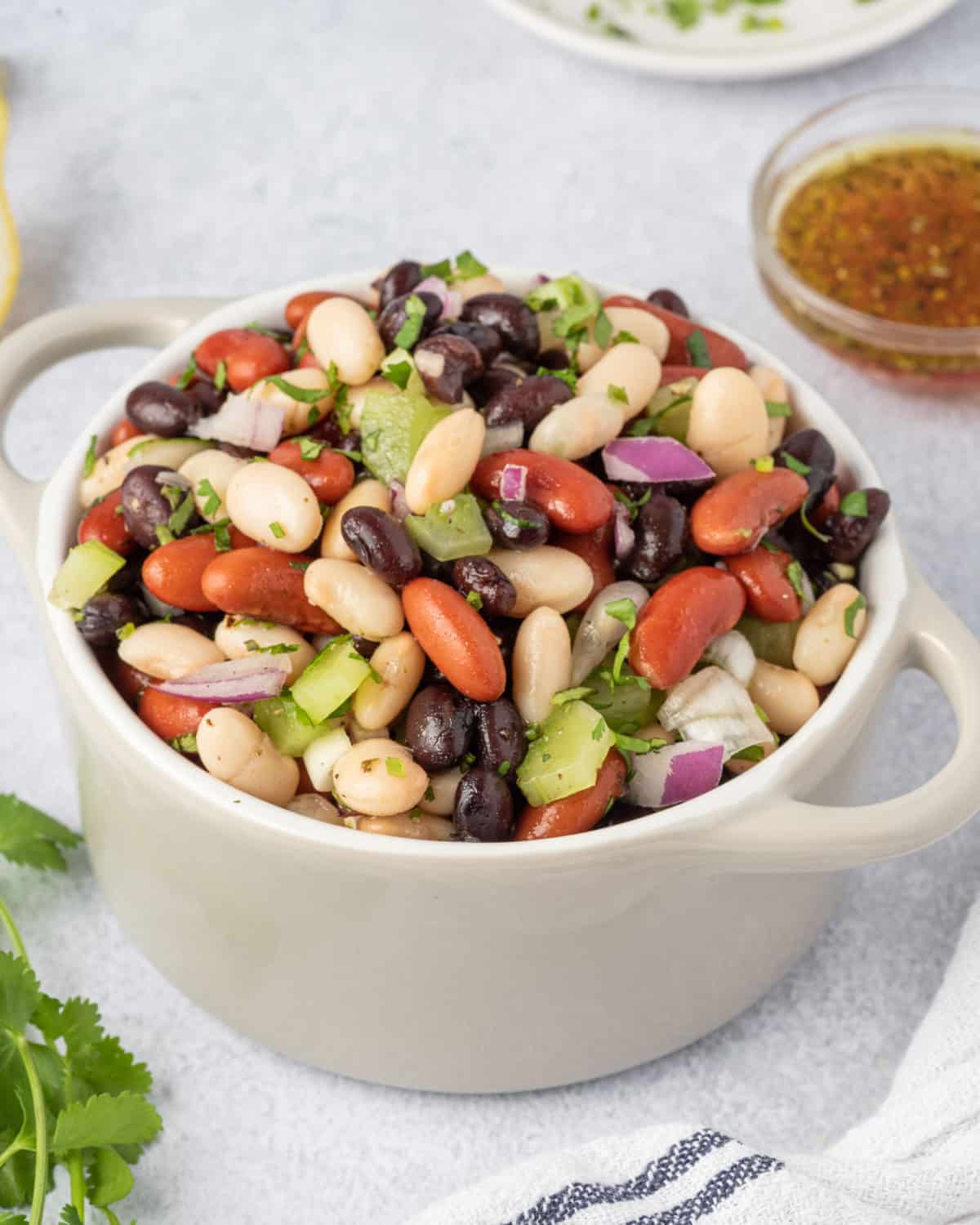 one bowl with three beans salad and dressing