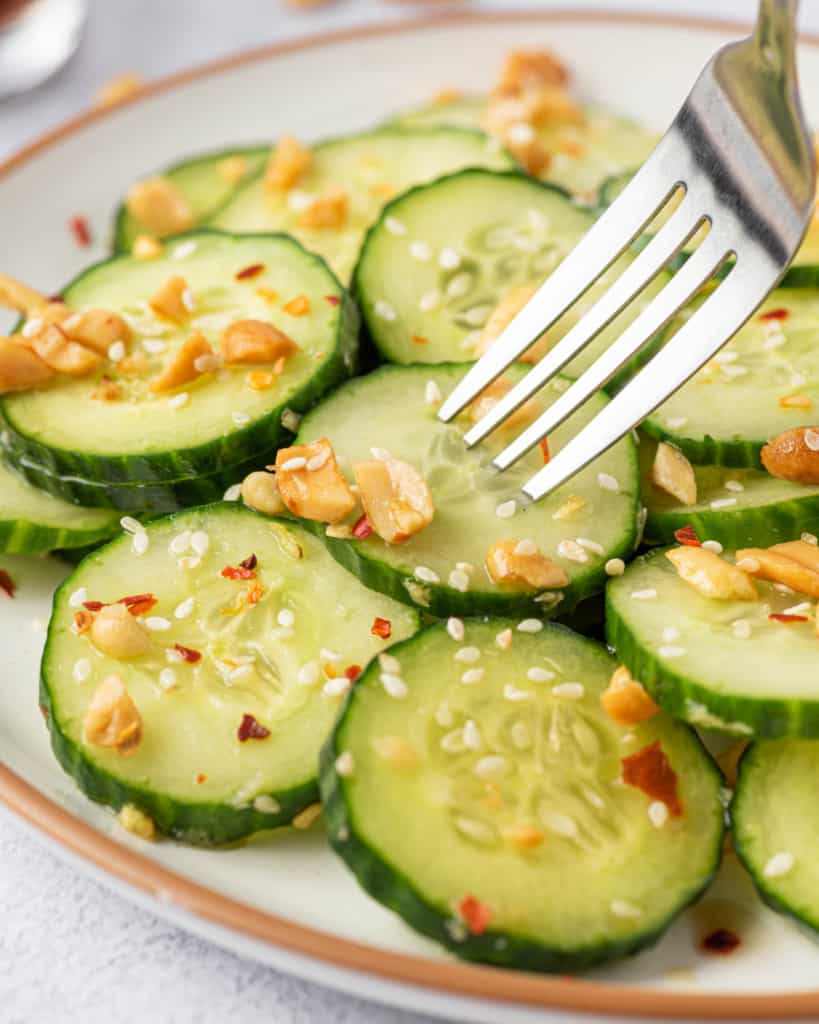 fork grabbing a slice of cucumber from plate 