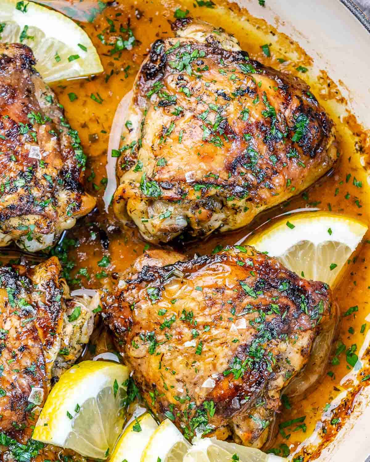 close view of baked chicken thighs with lemon and parsley