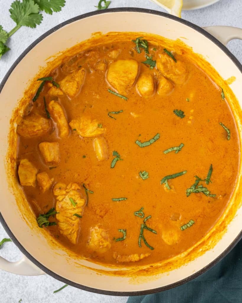 chicken mixed in the curry sauce in a pot