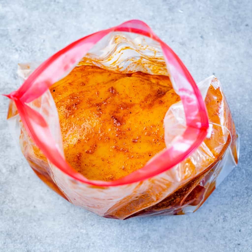 Chicken marinating in a ziplock bag.