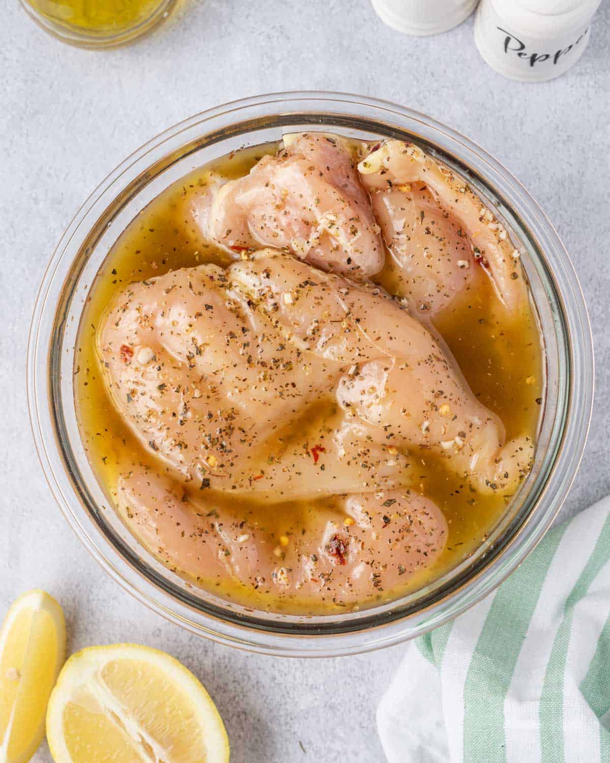 chicken breast in a bowl with marinade 
