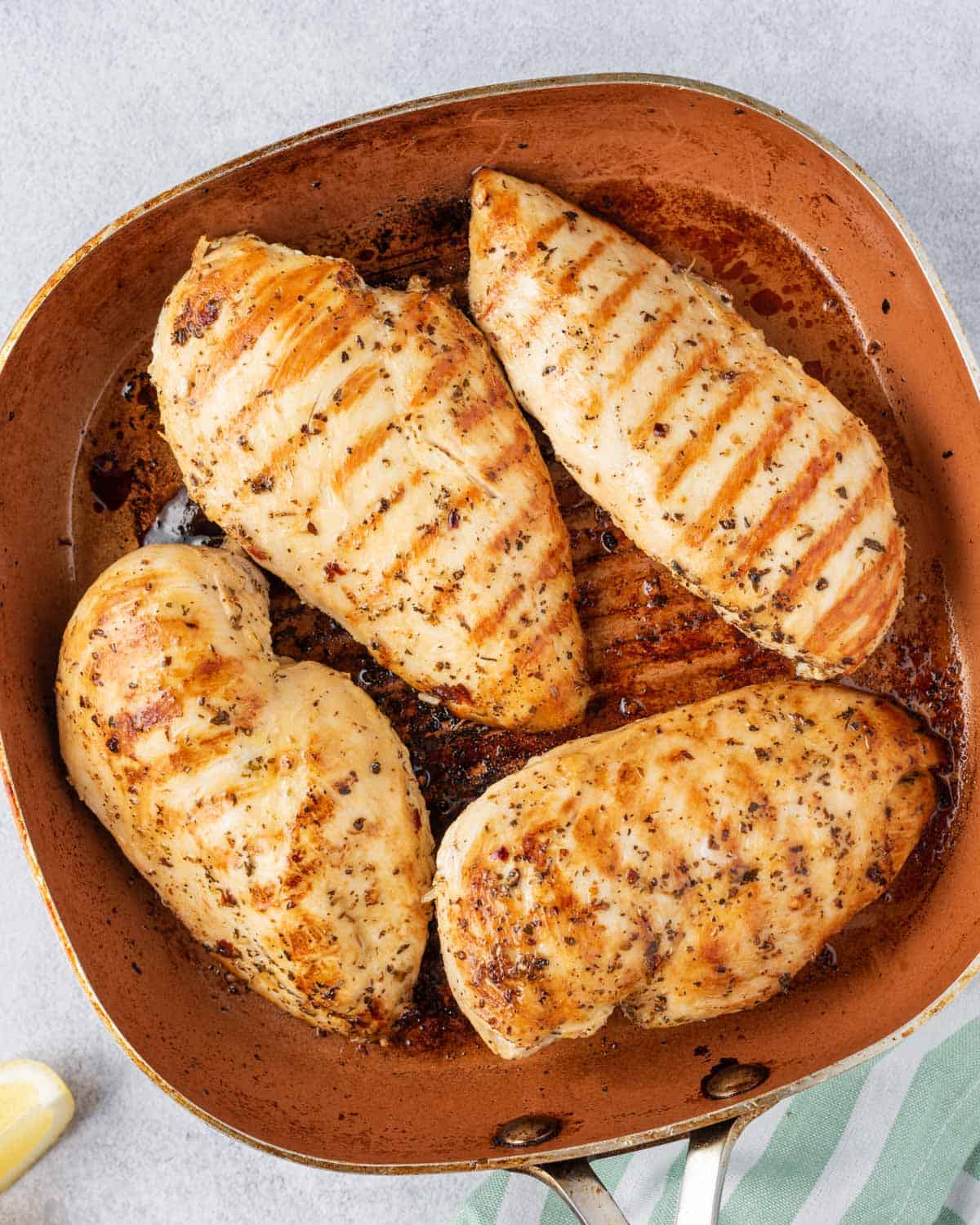 4 chicken breasts in grill pan being grilled 