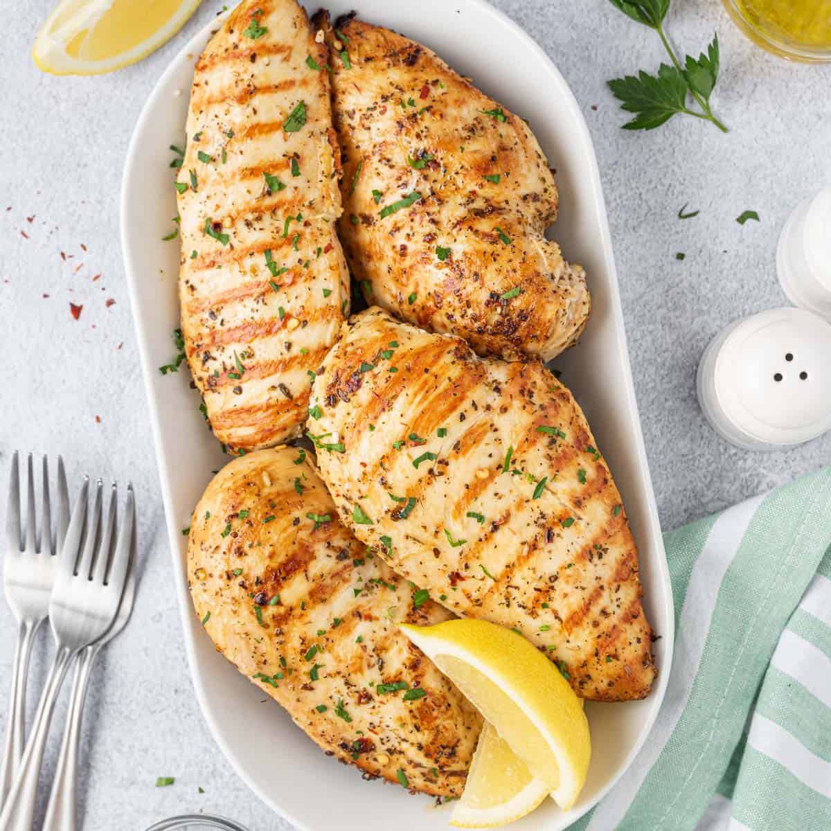 top view of 4 grilled chicken breast in a gold pan