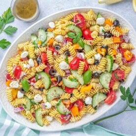 a white dish filled with Italian Pasta Salad.