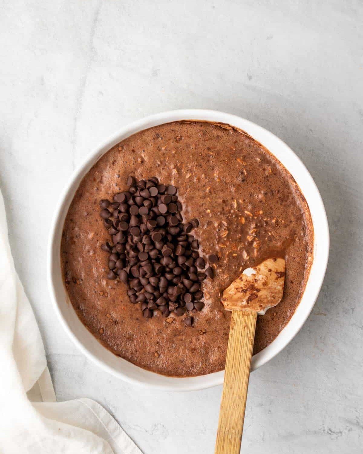 mixing chocolate chips into overnight oats with chocolate and peanut butter.