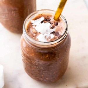 chocolate overnight oats in a jar topped with coconut flakes and chocolate chips