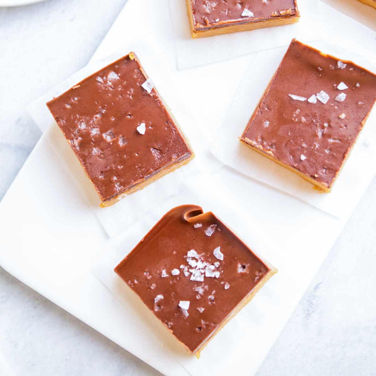 top view of 3 square peanut butter bars on white parchment paper