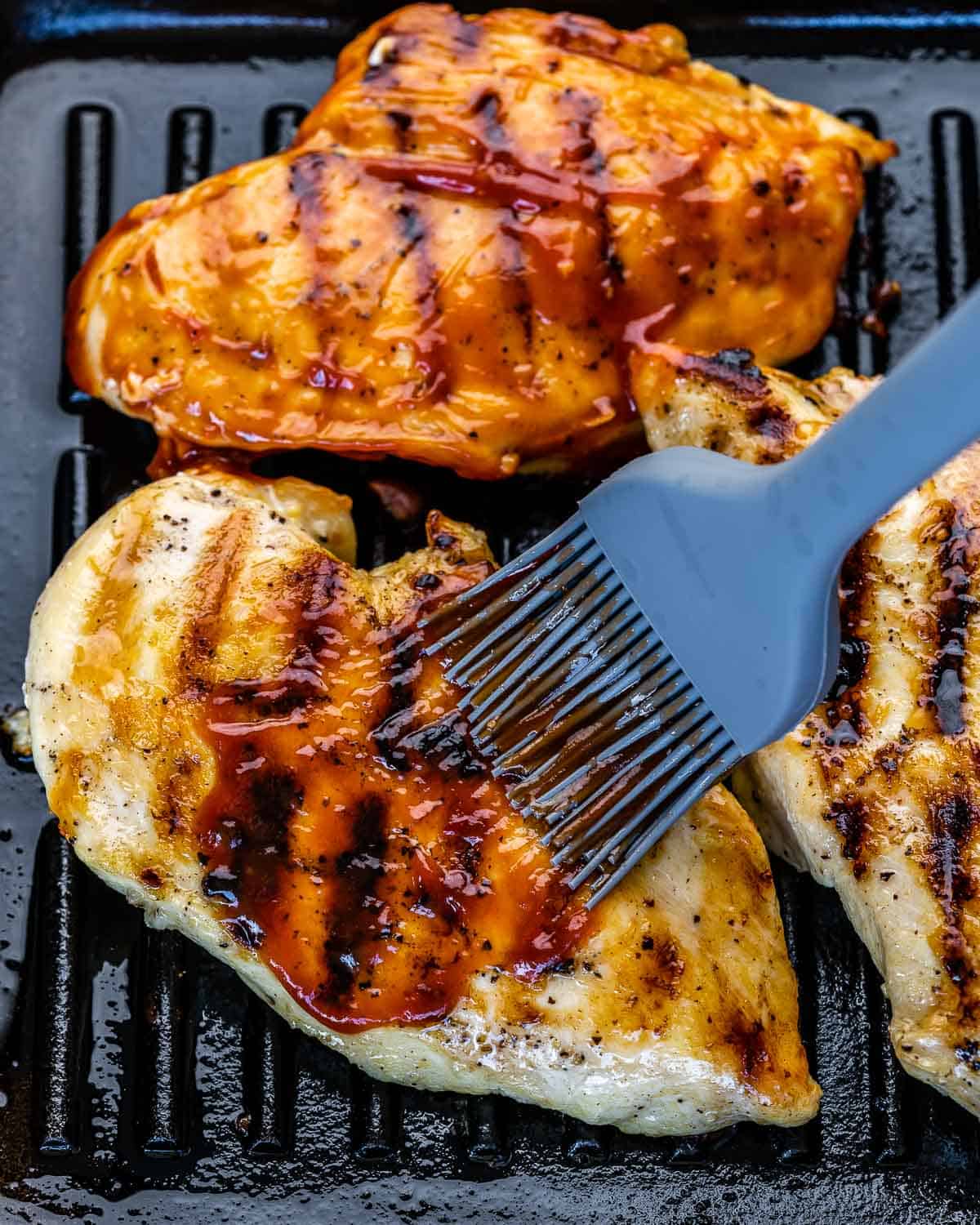 brushing chicken breasts with bbq sauce