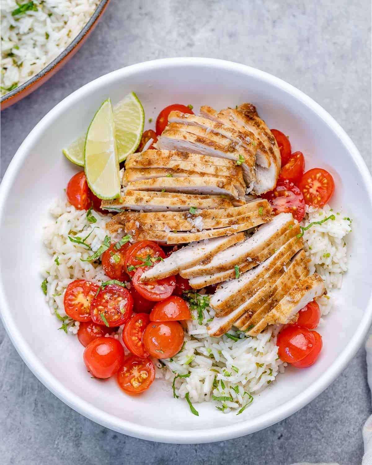 top view of cilantro lime chicken in bowl with tomatoes 
