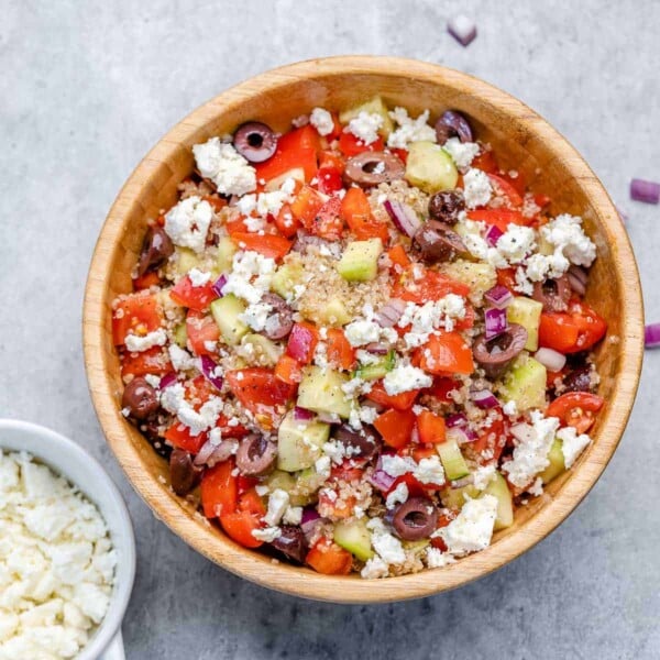 Mediterranean-style salad in a bowl with feta cheese, tomatoes., cucumbers, and quinoa