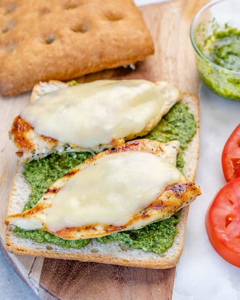 Cheese melting on chicken in an open sandwich.