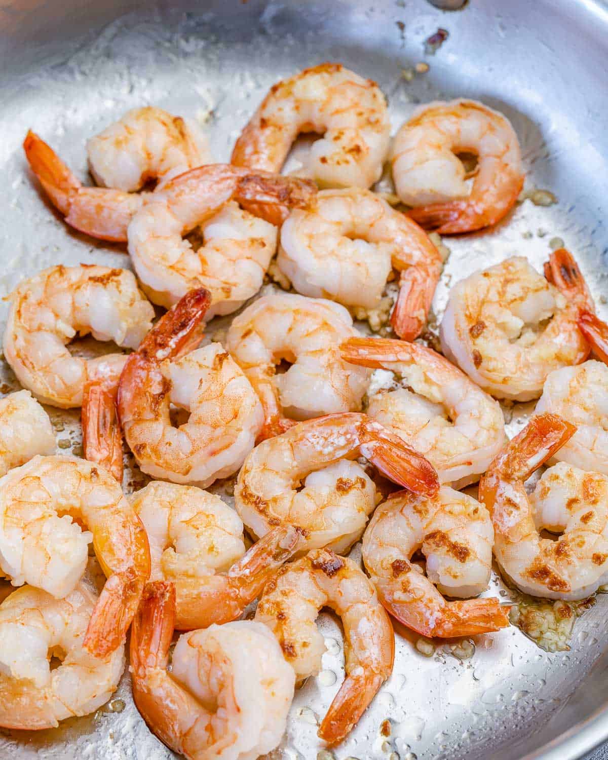 shrimp cooking in pan until pink