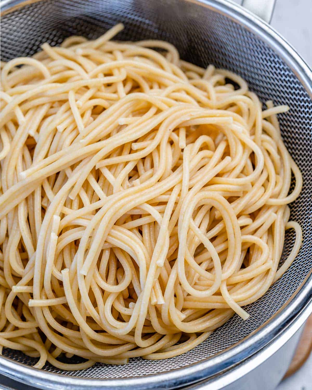 cooked spaghetti noodles being drained