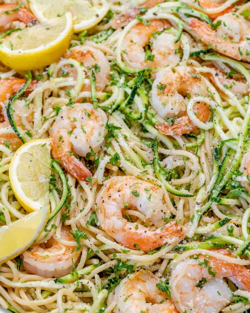 top view of shrimp in pan with pasta, lemon, parsley, and zoodles