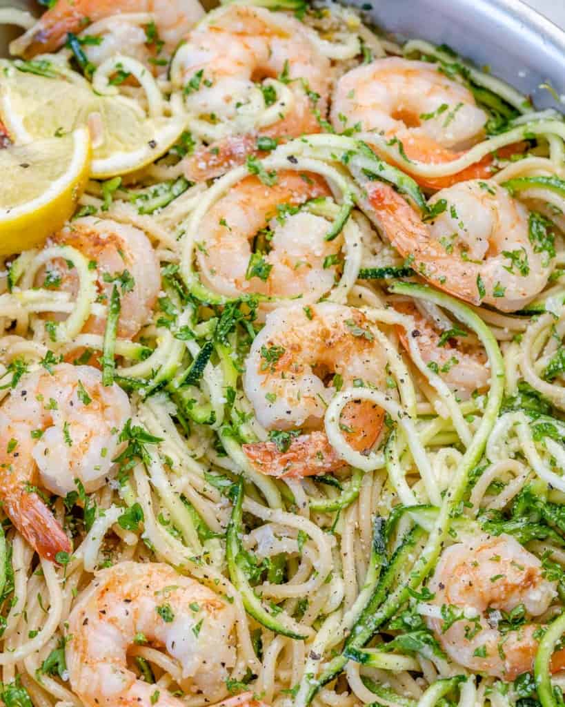 close view of lemon garlic shrimp pasta with parmesan cheese and lemon