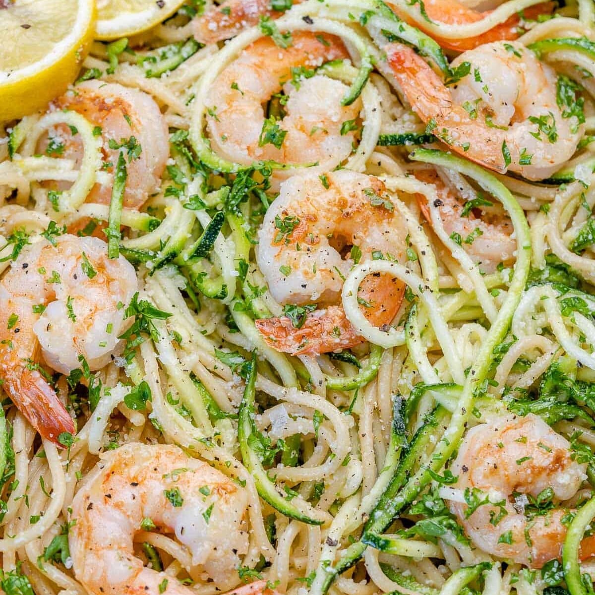 close view of lemon garlic shrimp pasta with parmesan cheese and lemon