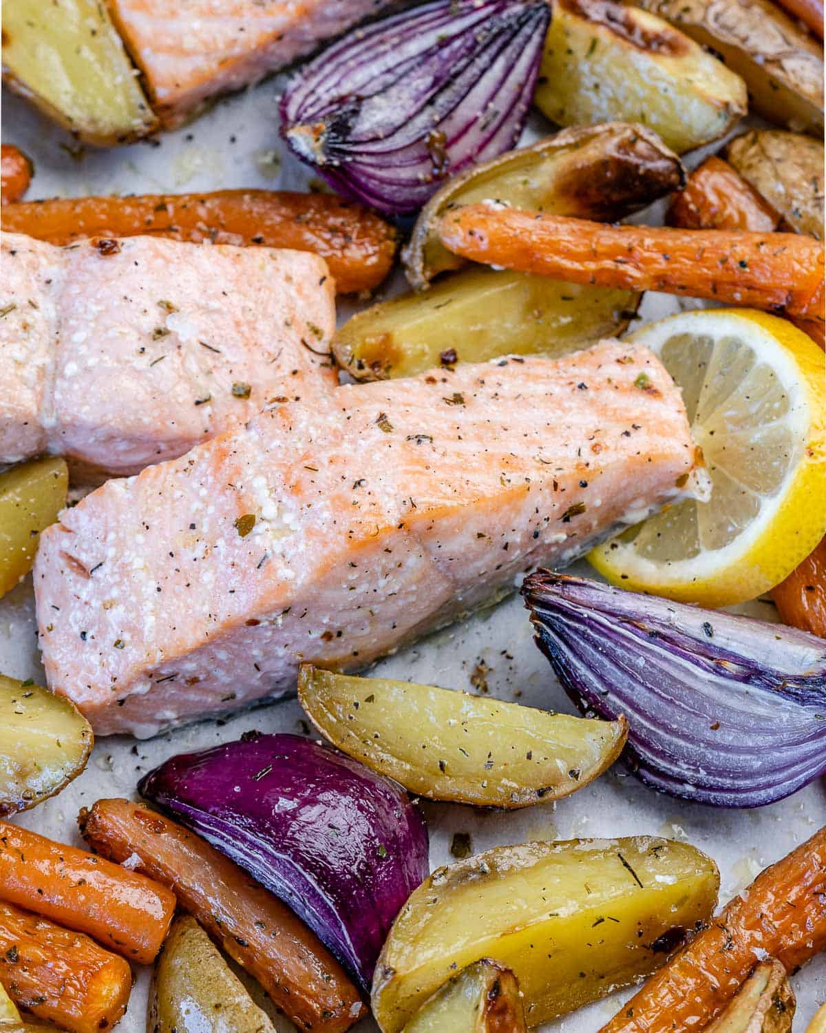 salmon fillets with lemon, potatoes, root veggies after baked in the oven