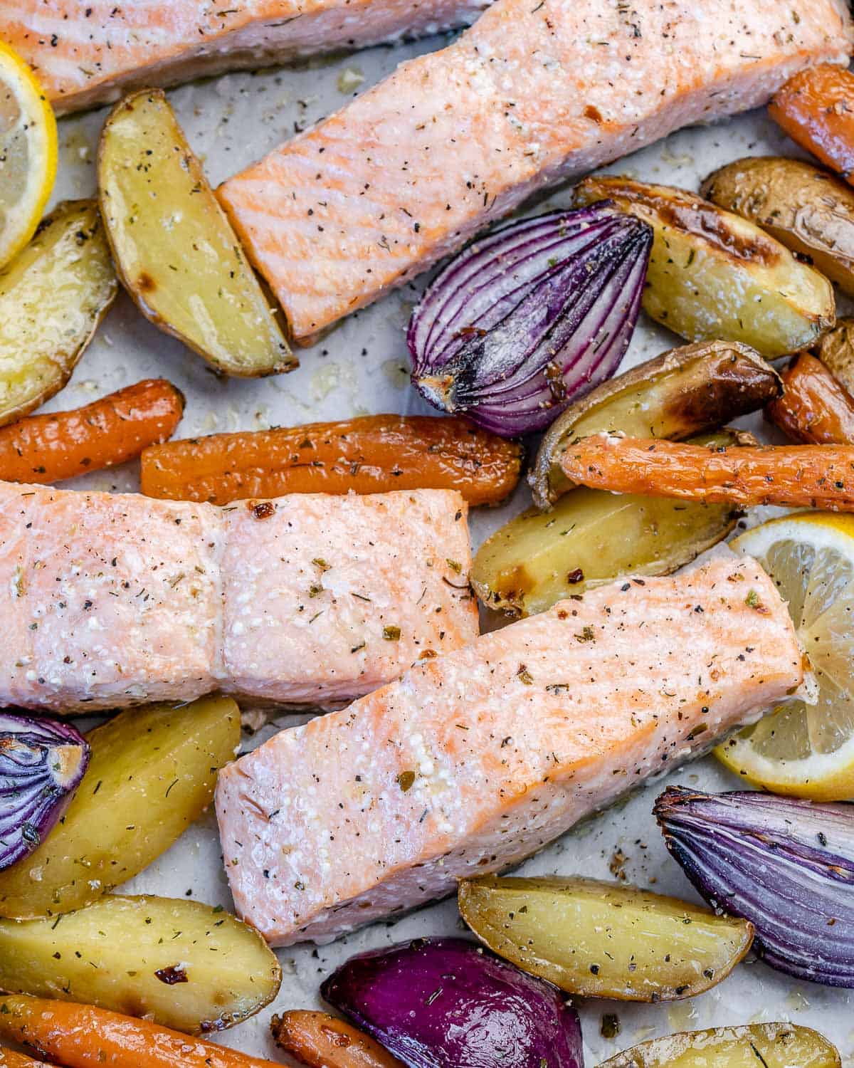 close view of oven-baked salmon with veggies and potatoes