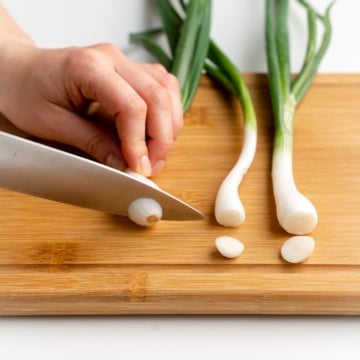 slicing green onions on a cutting board