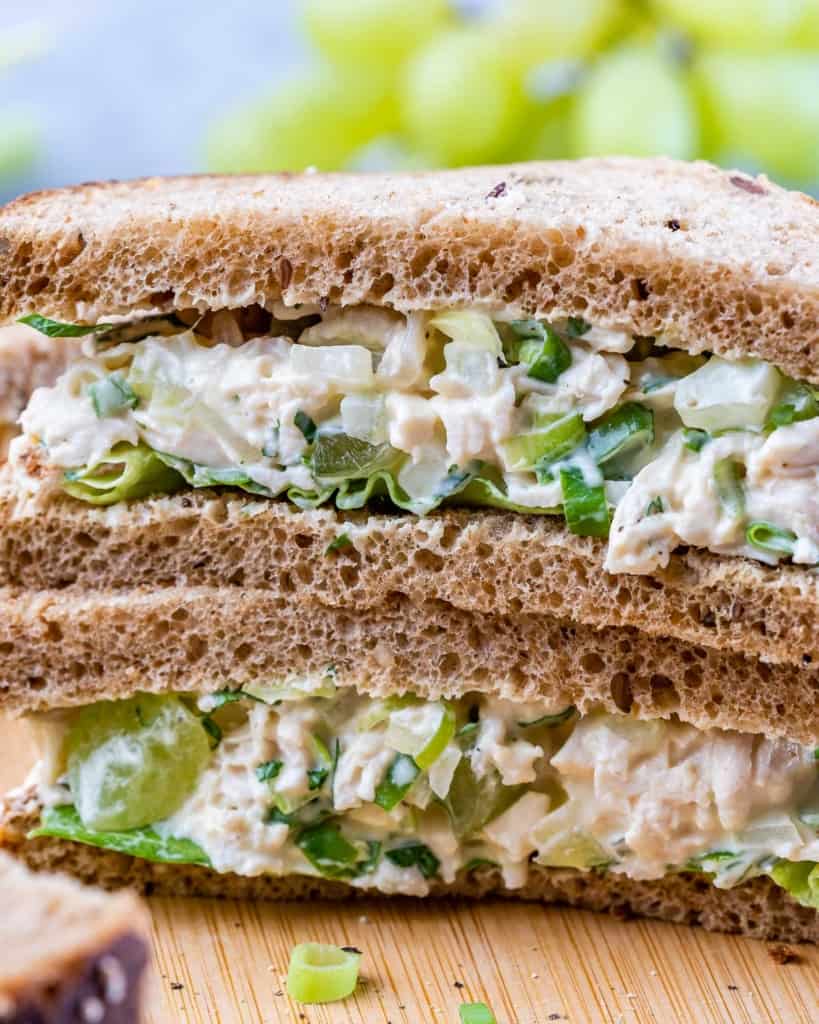 Closeup view of a chicken salad sandwich stacked on another chicken salad sandwich.