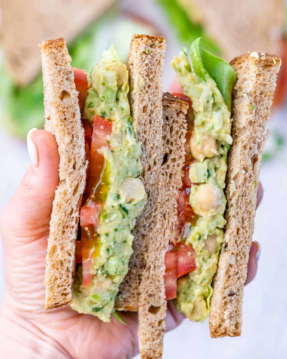 front view of avocado chickpea sandwich with lettuce and tomatoes