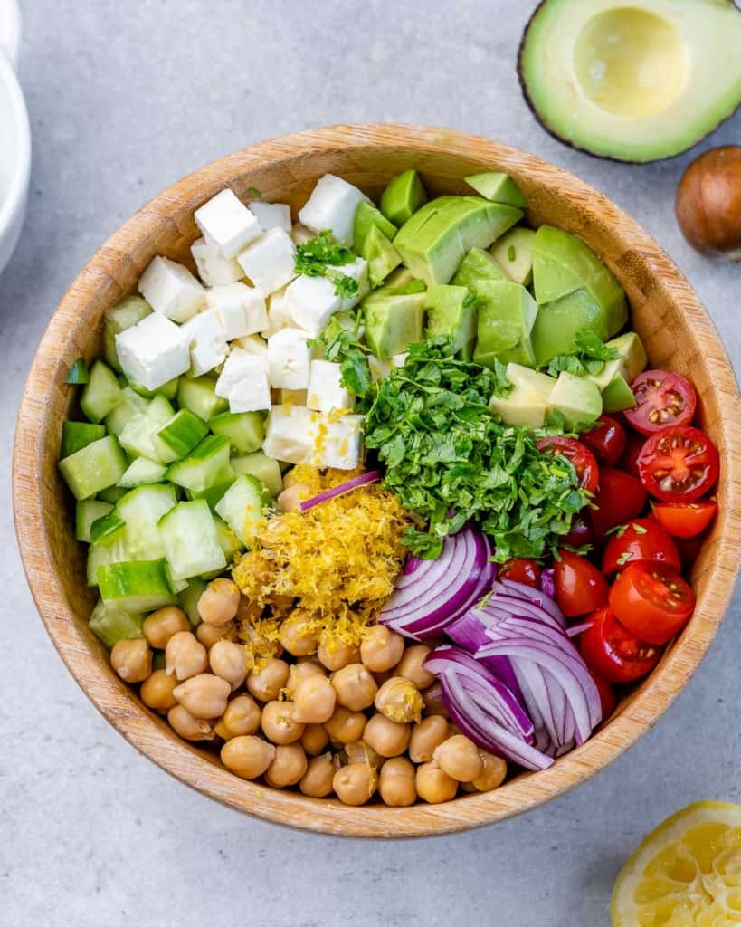 Chickpea Feta Salad ingredients individually placed in a wooden bowl (not mixed).