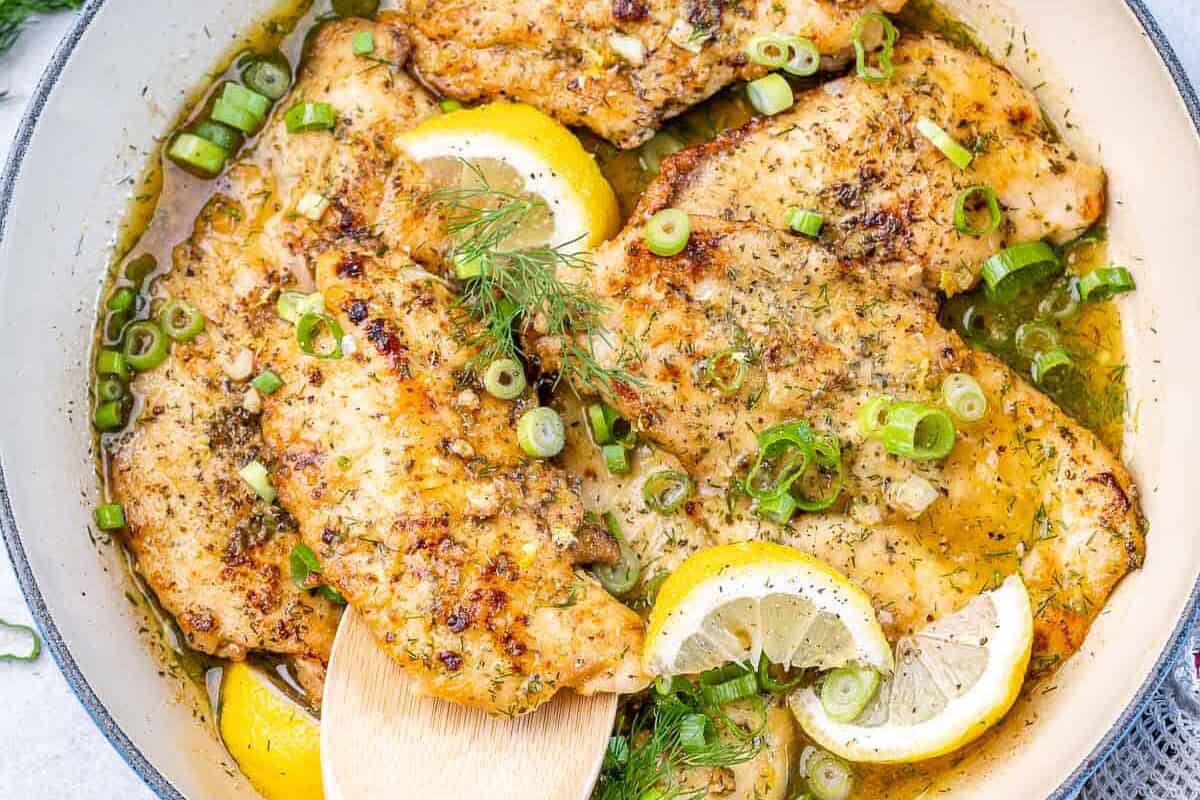 one skillet with lemon chicken breasts in sauce
