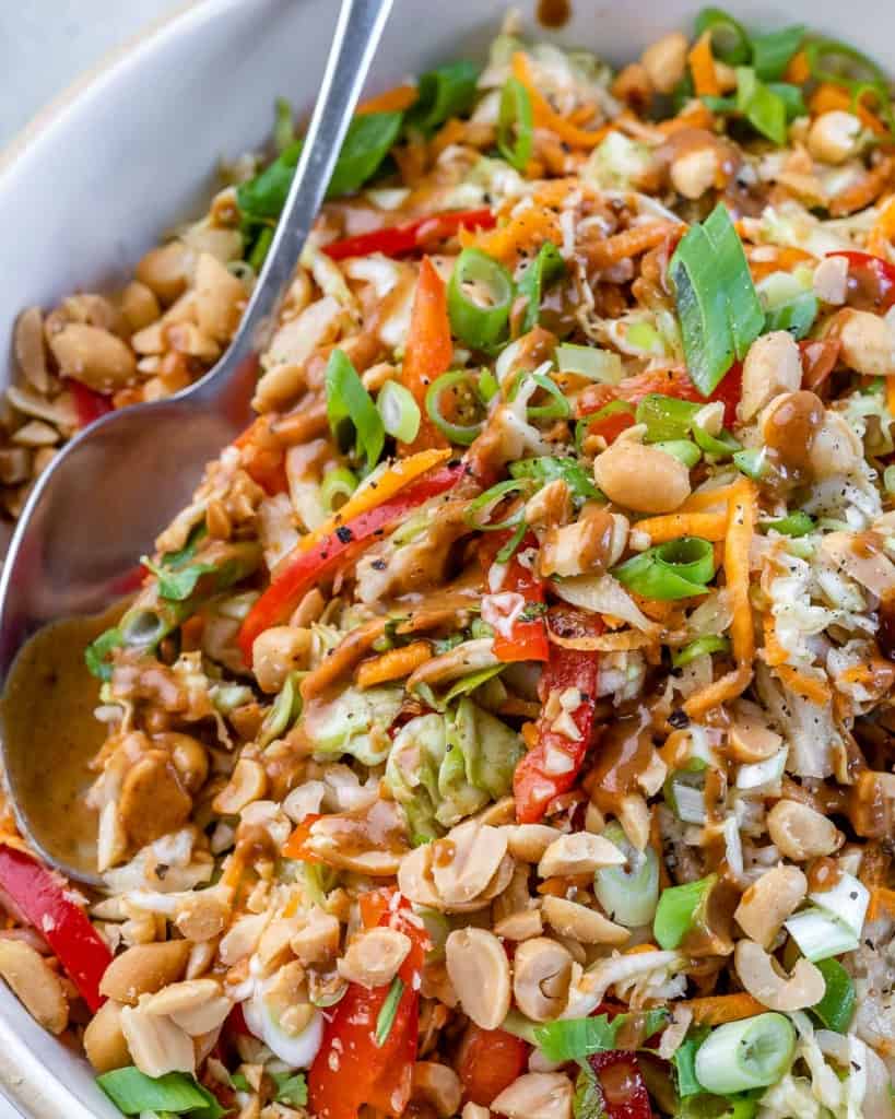 close up image of thai salad with spoon in bowl