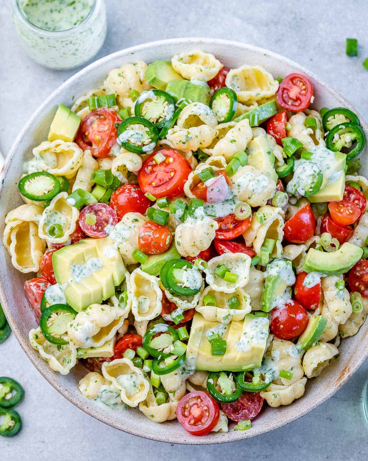 cilantro lime pasta salad in one bowl with dressing