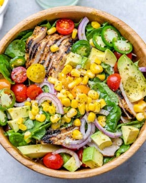 top view of grilled chicken salad in a wooden bowl