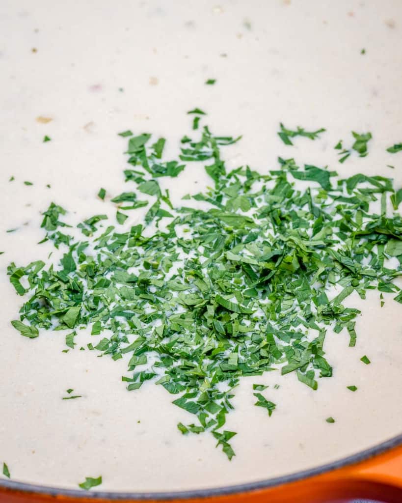Adding fresh parsley to a creamy sauce.