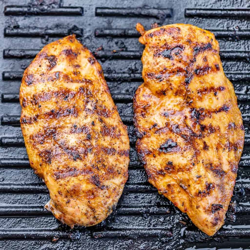 Top view of grilled chicken on a black grill.