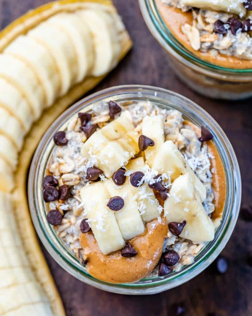 Overhead view of overnight oats topped with banana slices, peanut butter and mini chocolate chips.